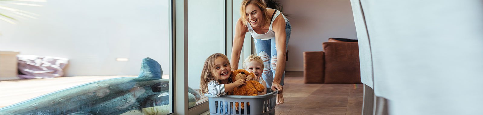 Mother pushing laundry basket with children