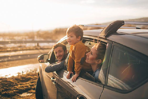 A family in a car looking at the sunset