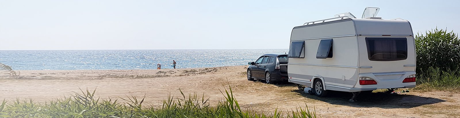 Caravan parked on a sunny quiet beach
