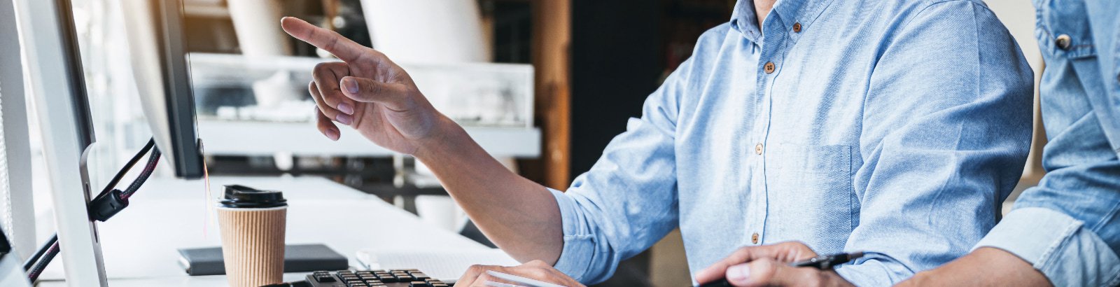 Two men working together in front of a computer