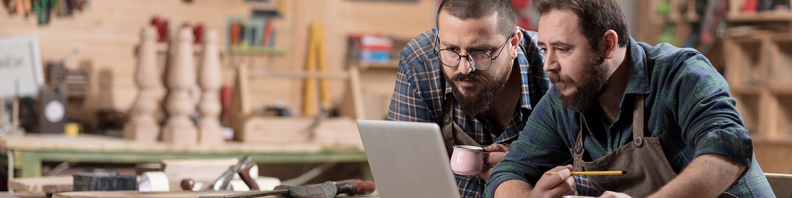 Two men in workshop looking at a laptop