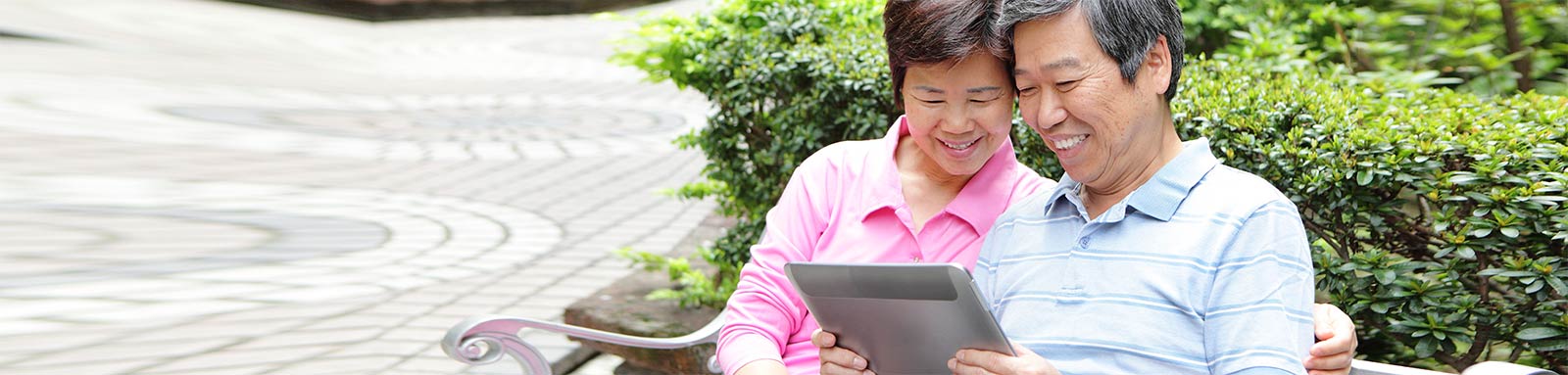 Senior couple looking at tablet in a park