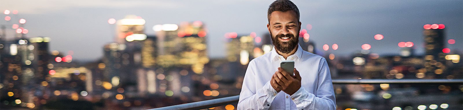 Man using phone at night in city