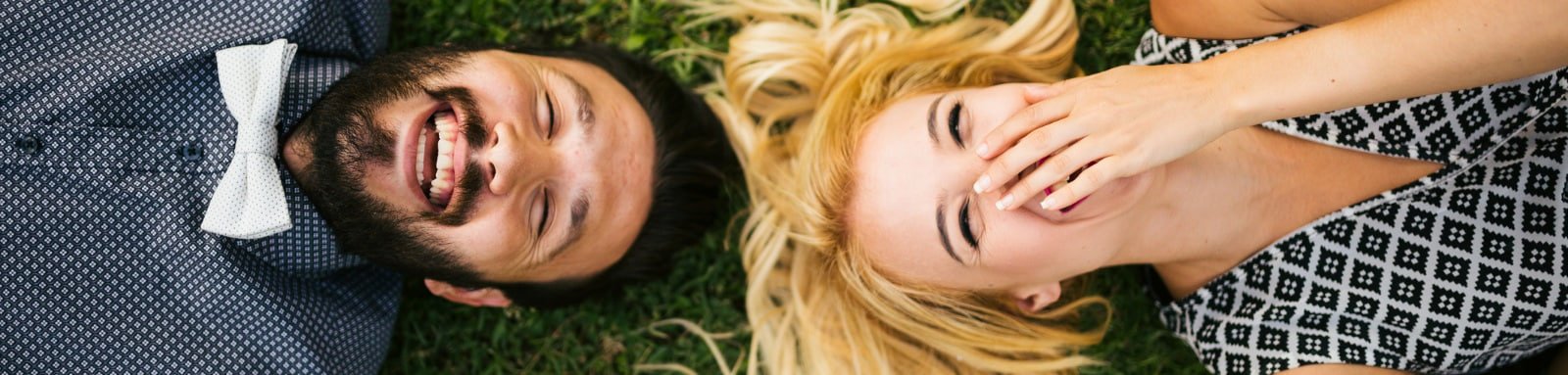 Couple lying on grass laughing