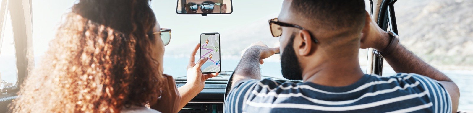 Couple looking at phone GPS in the car