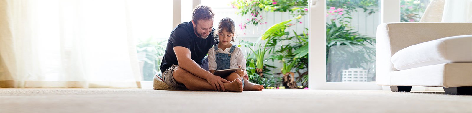 Dad and daughter reading book on the floor