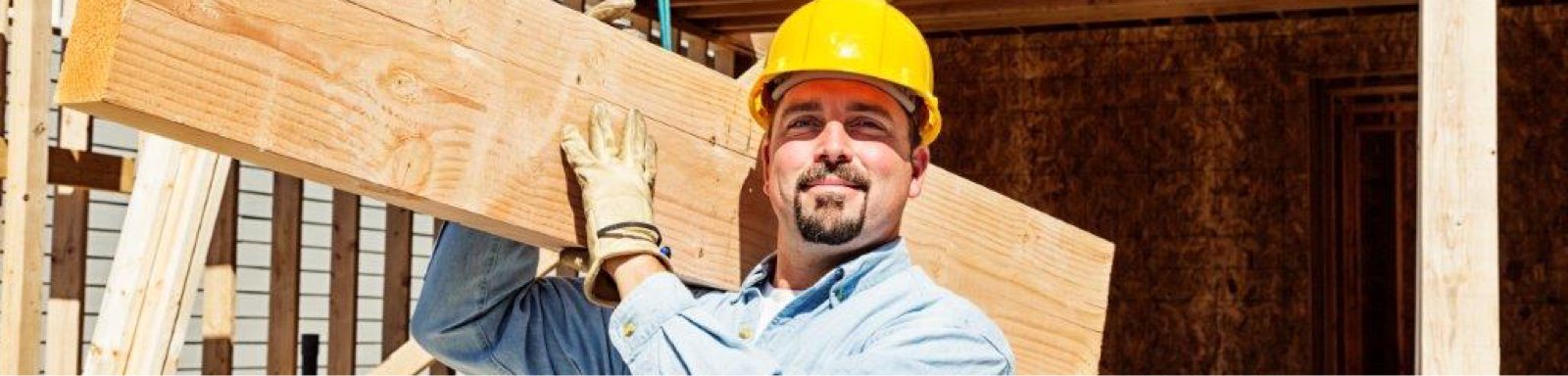 Smiling tradesman lifting building material