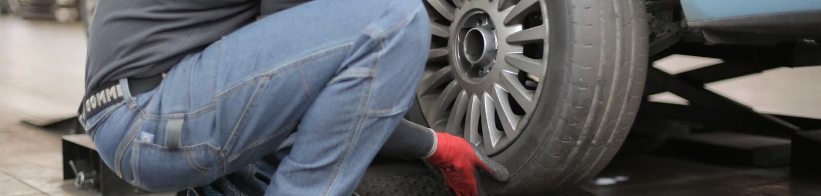 Man changing tyre wearing gloves