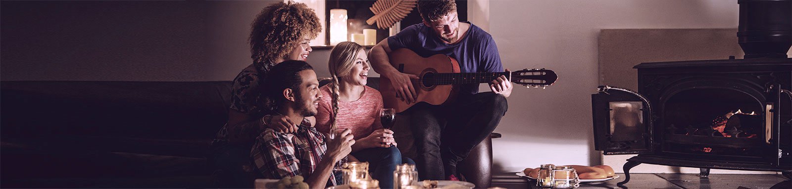 Group of friends play music in front of fireplace