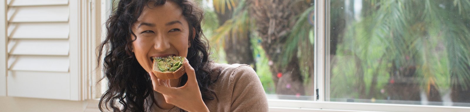 Woman eating avocado on bread