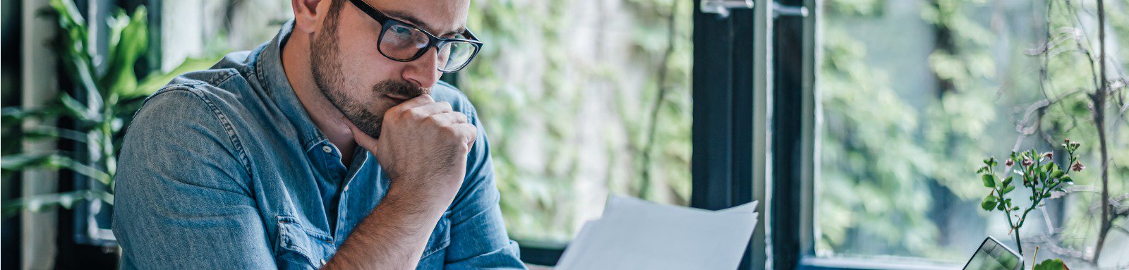 Man analysing documents in front of laptop