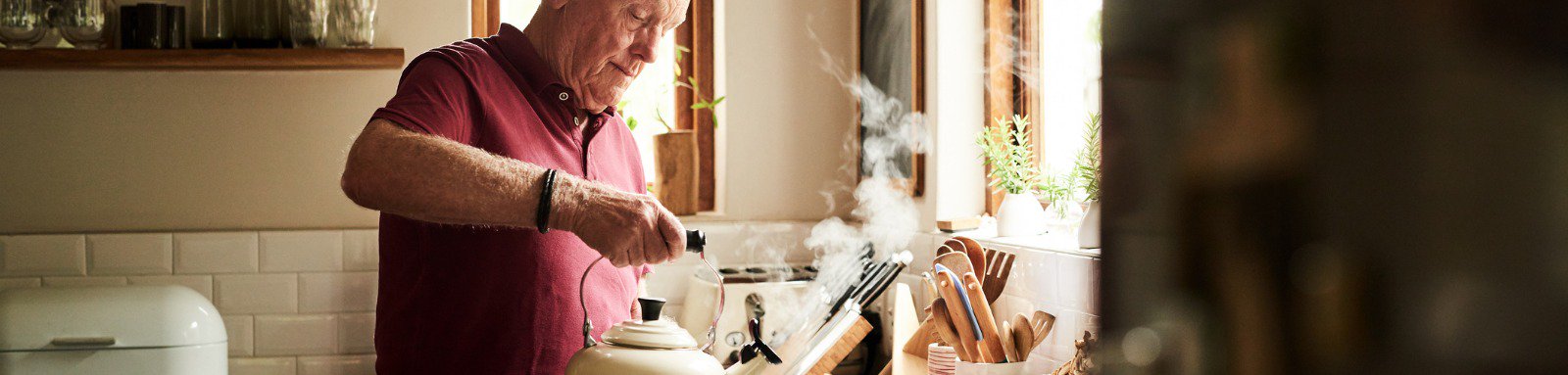 Man in kitchen making cup of tea