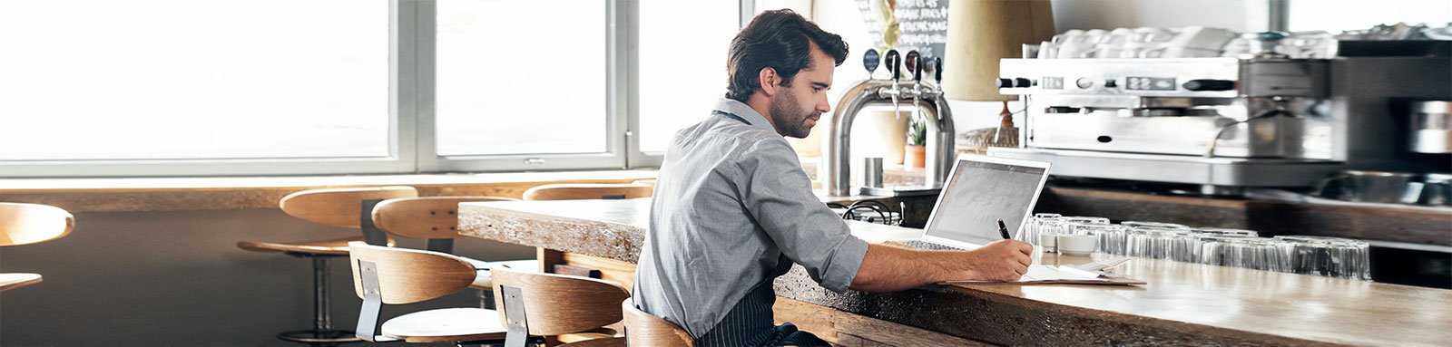 Man sitting at cafe counter with laptop computer