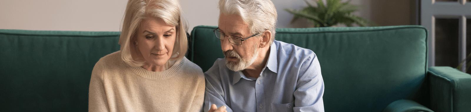 Senior couple having intimate conversation on couch