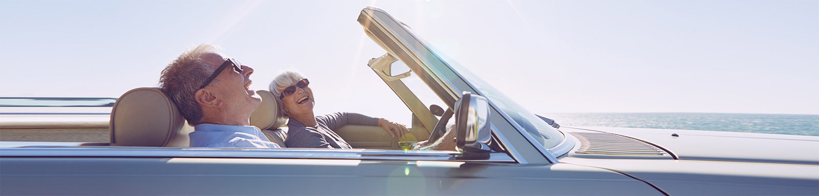 Senior couple driving a convertible