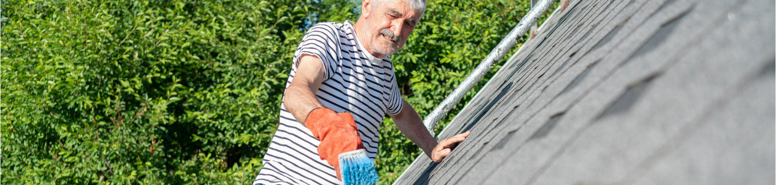 Senior man cleaning roof gutters