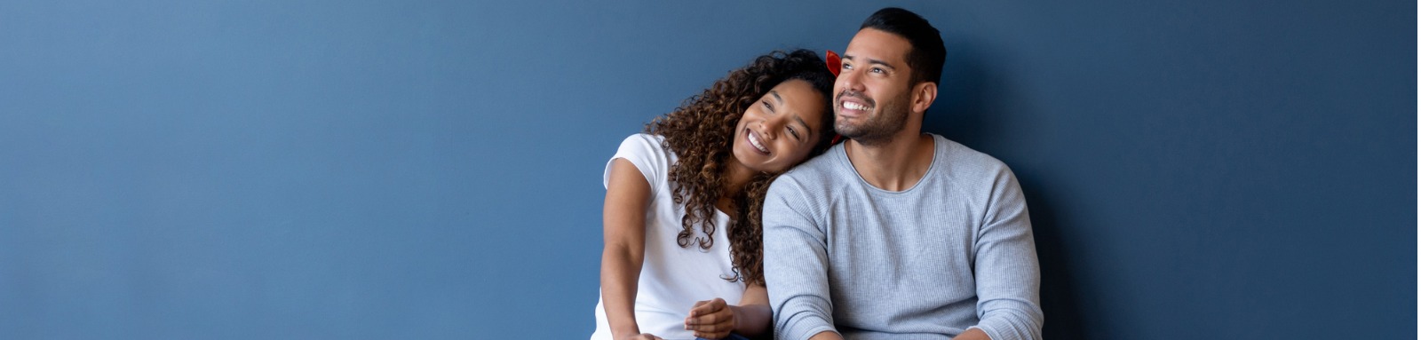 Smiling man and woman sit on floor