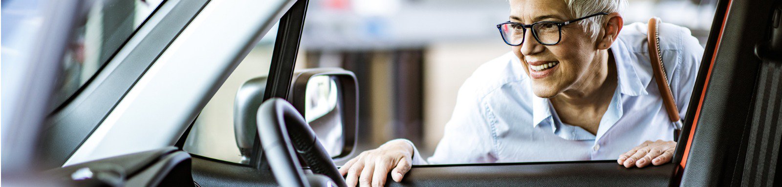 Smiling woman looking through car window 