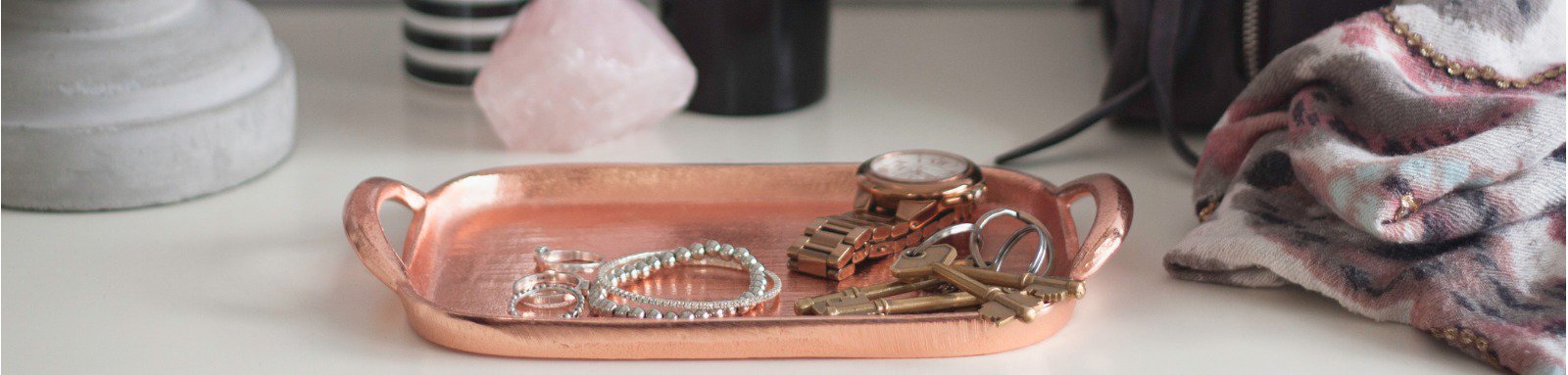 Table display featuring jewellery a vase and a bag