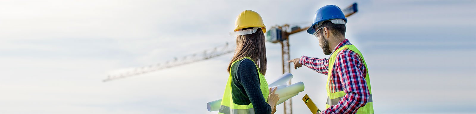 Two workers in hardhats at construction site