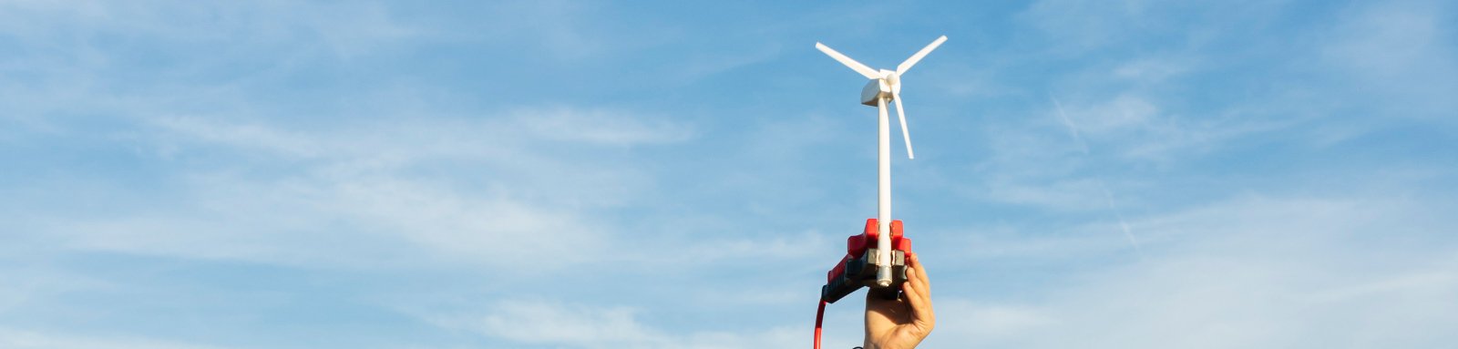 Woman holds up micro wind turbine