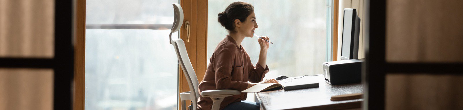 Woman sitting on ergonomic chair in front of computer