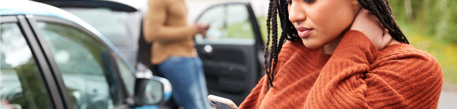 Woman using phone after car accident