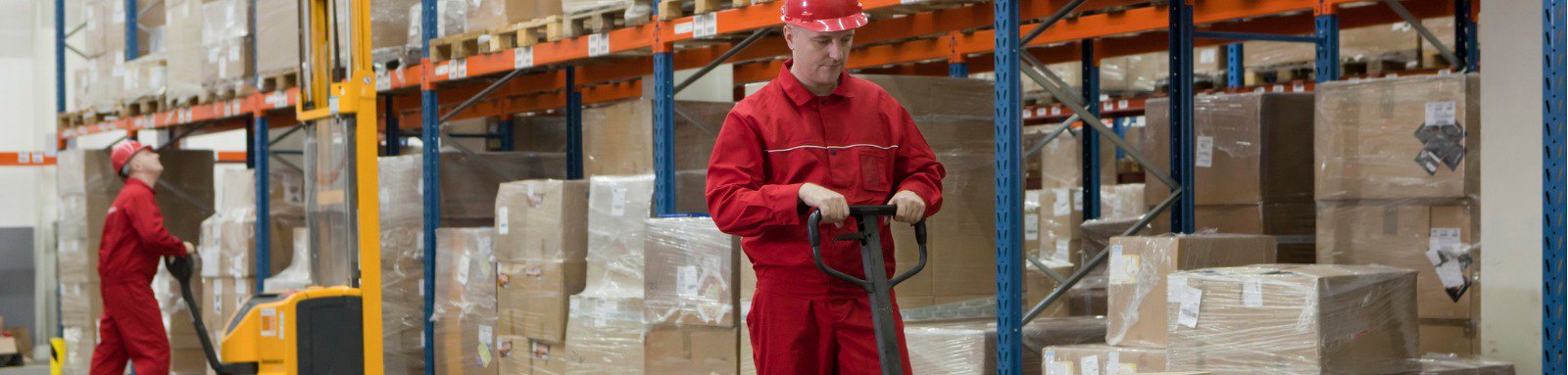 Worker in warehouse lifting boxes with trolley