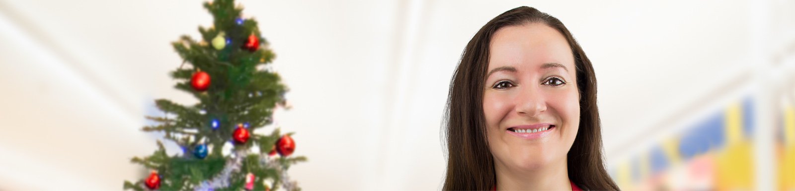 Smiling woman next to Christmas tree