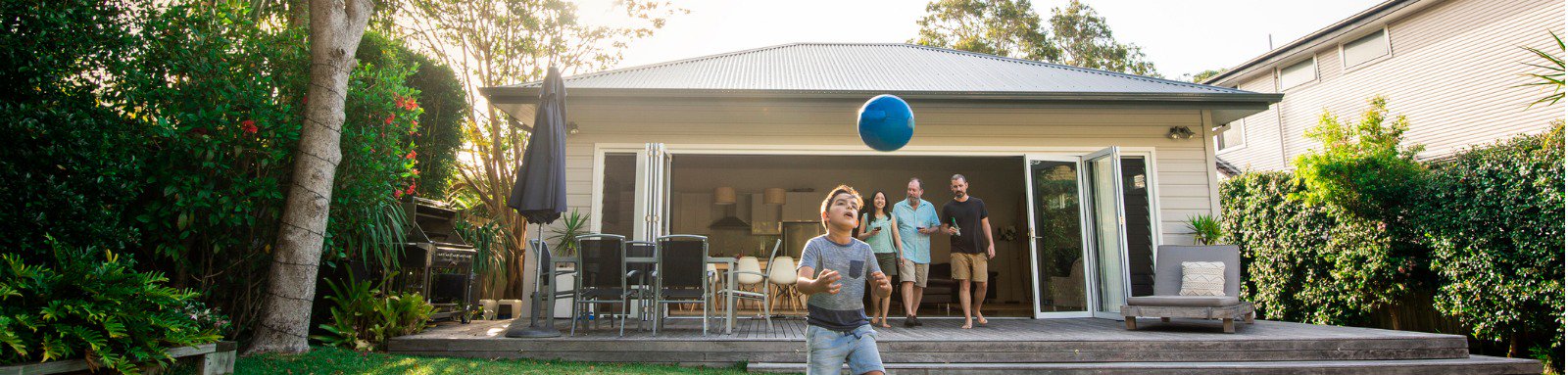 Young boy playing with ball in yard