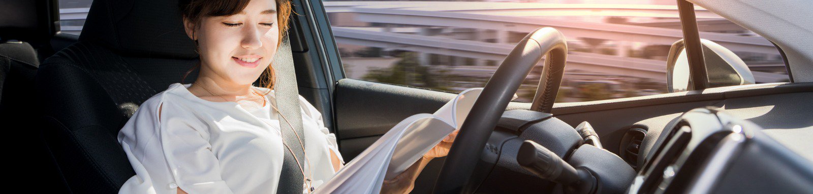 Young woman reading a magazine in self driving car