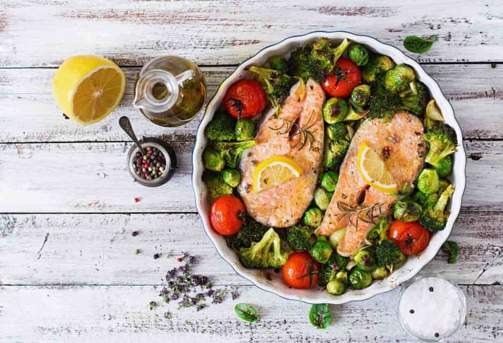 Roasted fish and vegetables on rustic table