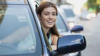 Young woman leaning out of car