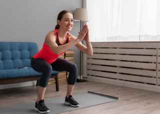 Woman doing squats in lounge room