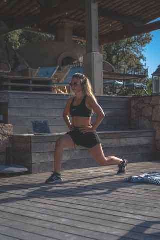 Woman doing forward lunge outside